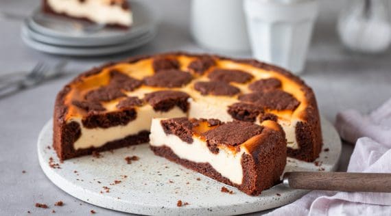 Angeschnittener Russischer Zupfkuchen auf einer Platte, ein Stück steht im Vordergrund quer. – Foto: Anna Gieseler