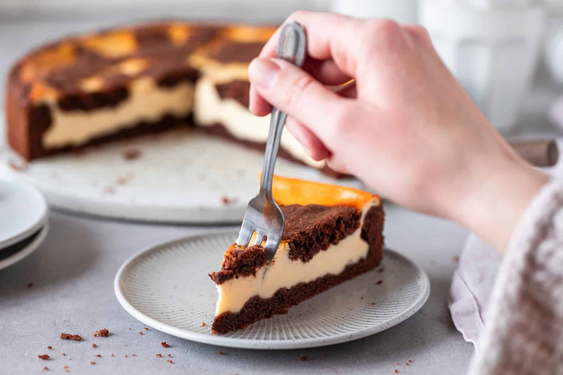 Ein Stück Russischer Zupfkuchen auf einem Teller – Jemand sticht ein Stück mit einer Gabel ab – Foto: Kathrin Knoll