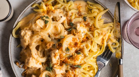 Ein grauer Teller von oben fotografiert, darauf Spätzle, Soße, Fleisch