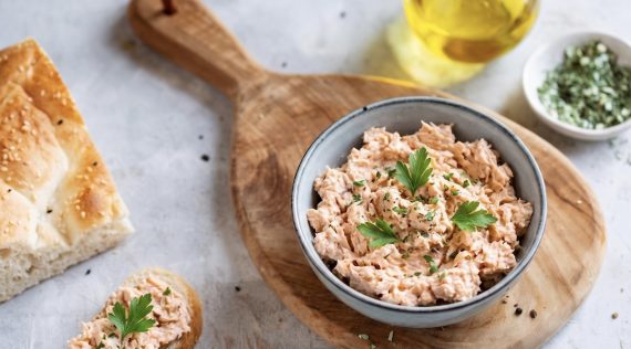 Lachs-Dip in einer Schale auf einem Holzbrett