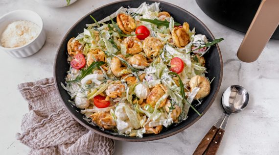Eine Pfanne mit einem bunten Salat von oben fotografiert, Tomaten, Tortellini, Eisbergsalat