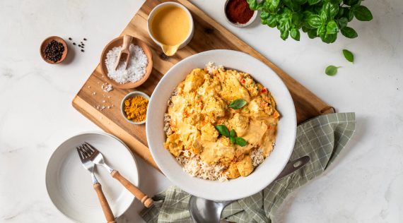 Ein Teller mit Hähnchenfilet in cremiger Soße und Reis, von oben fotografiert – Foto: Anna Gieseler