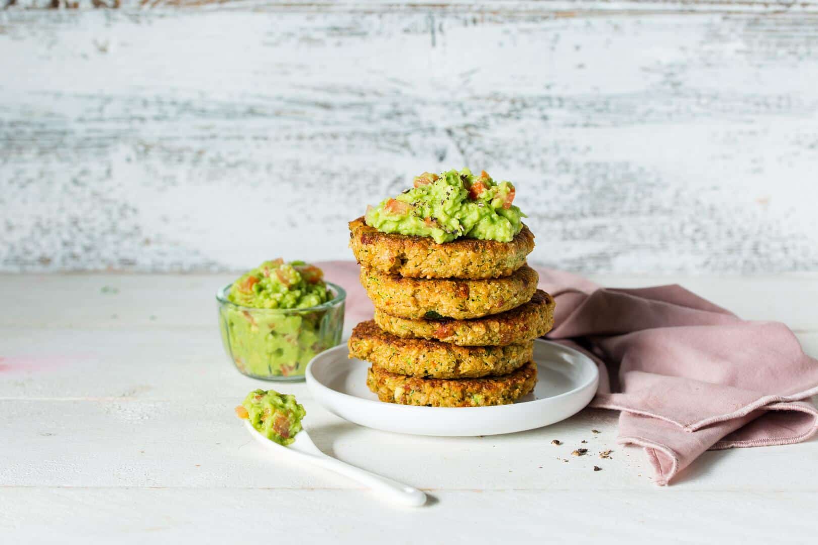 Gemüsepuffer aufeinander gestapelt, als Topping Avocadocreme