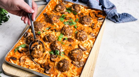 Ein Blech mit Hackbällchen in Soße mit Spätzle und Champignons