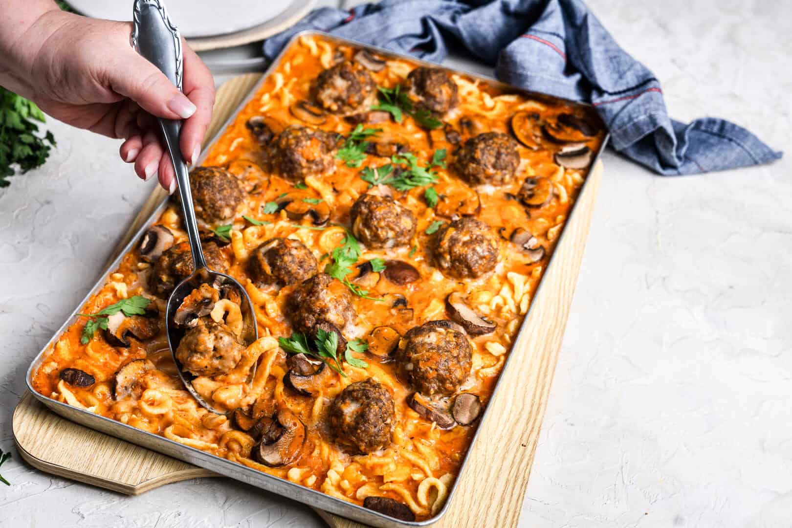 Ein Blech mit Hackbällchen in Soße mit Spätzle und Champignons