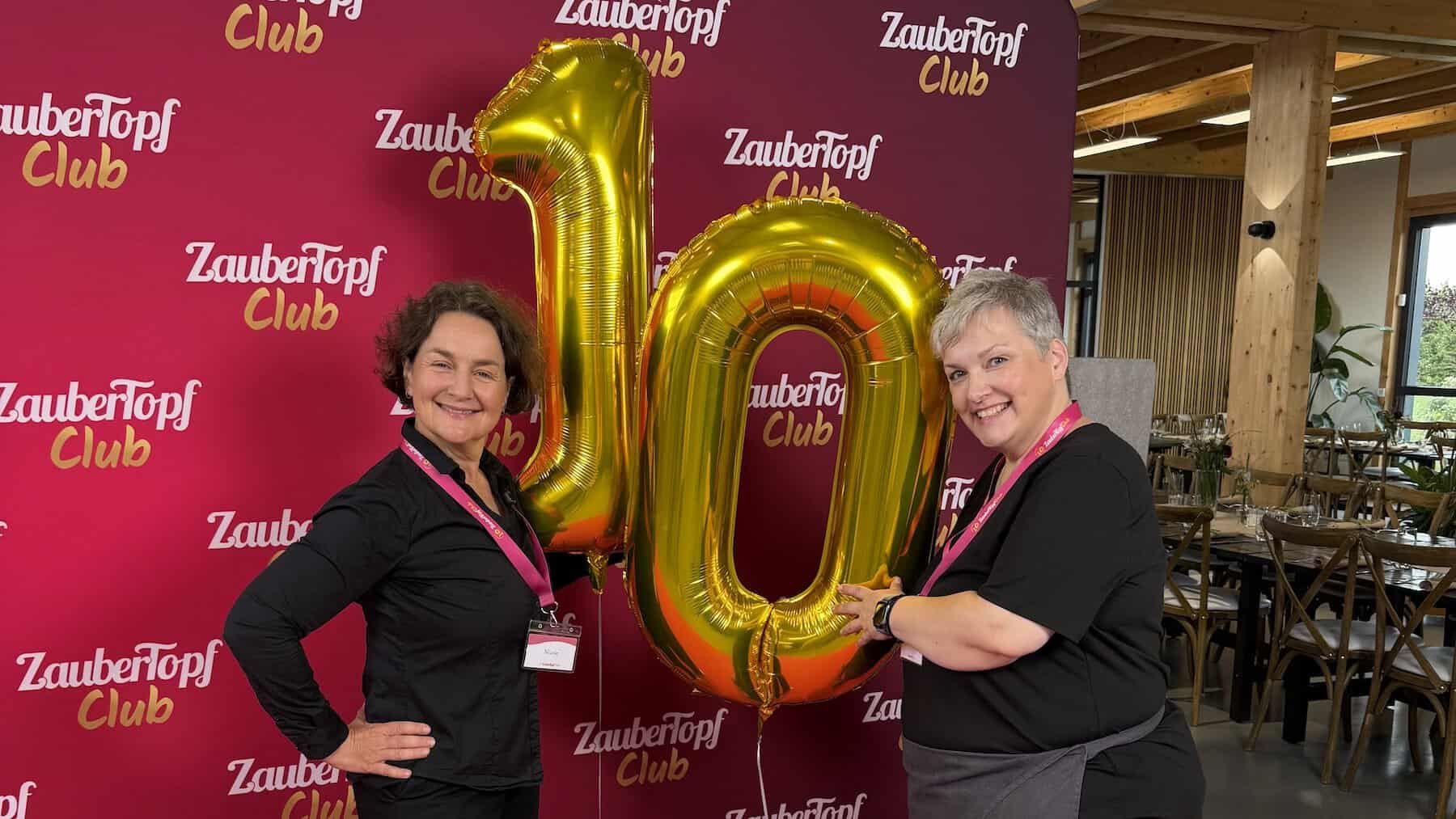 Zwei Frauen mit goldenen Luftballons in Form einer 10